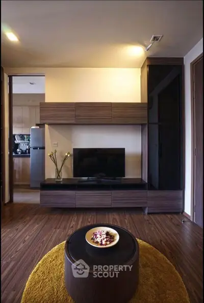 Modern living room with sleek wooden furniture and flat-screen TV, featuring a cozy ambiance.