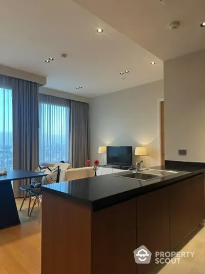 Modern open-plan living room with sleek kitchen island and large windows.