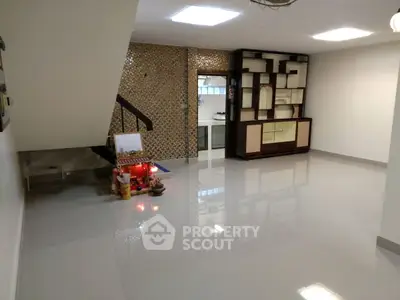 Spacious open-plan living area with modern decor and sleek tiled flooring.