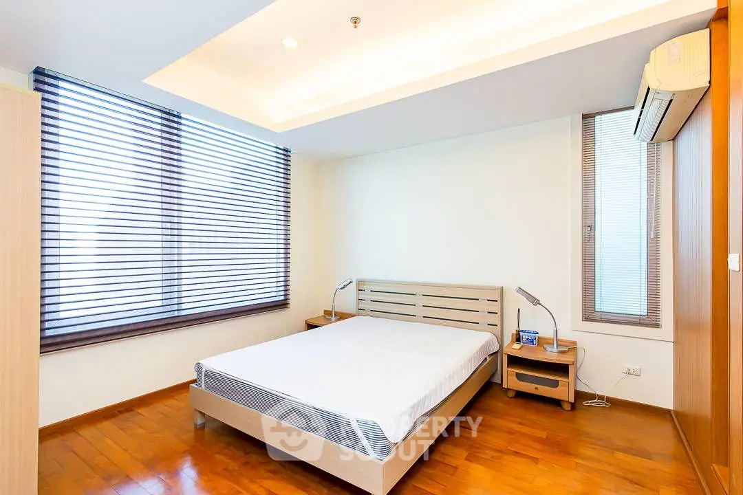 Modern bedroom with slanted windows and wooden flooring