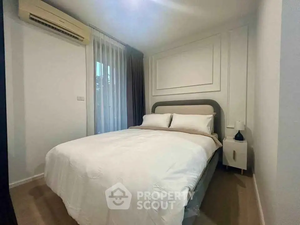 Cozy bedroom with modern decor and natural light, featuring a comfortable bed and stylish air conditioning unit.