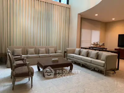 Elegant living room with high ceilings, classic furniture, and large windows for natural light.
