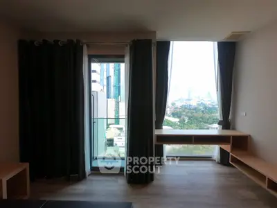 Spacious living room with floor-to-ceiling windows offering stunning city views.