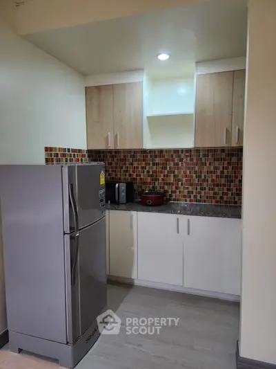 Modern kitchen with sleek fridge and stylish mosaic backsplash