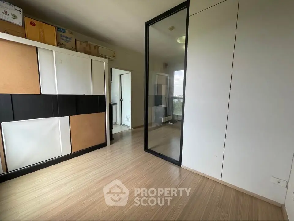 Spacious room with modern storage and large mirror, ideal for versatile use.