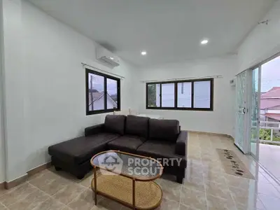 Spacious living room with modern sofa and large windows offering natural light.
