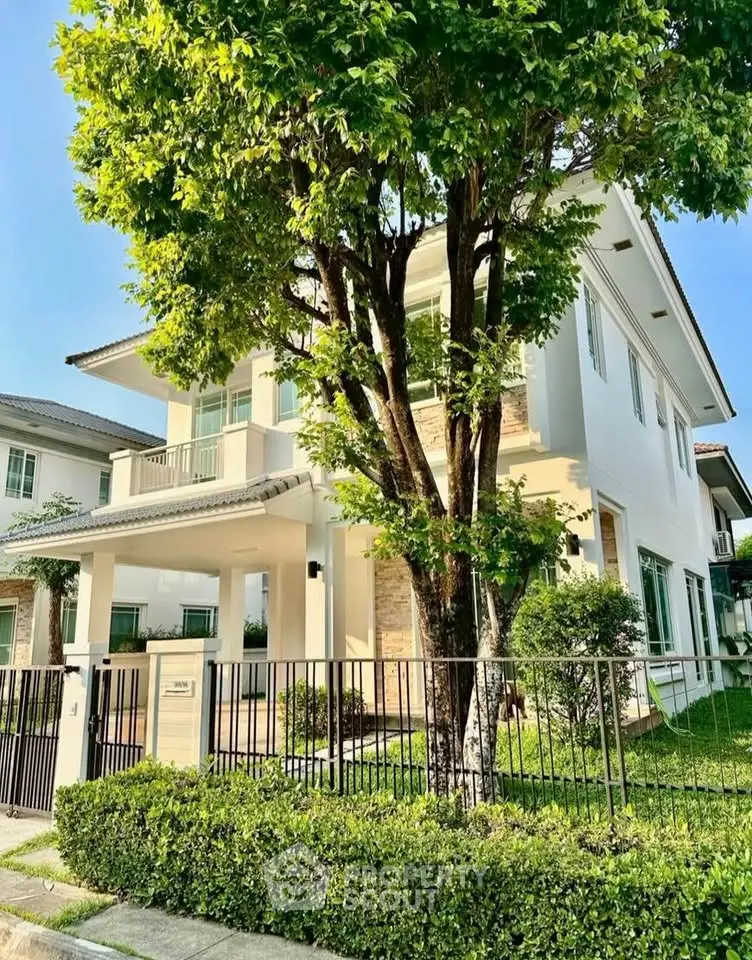 Elegant two-story house with lush garden and modern architecture in a serene neighborhood.