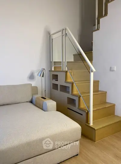 Modern living room with stylish staircase and cozy sofa, perfect for urban living.