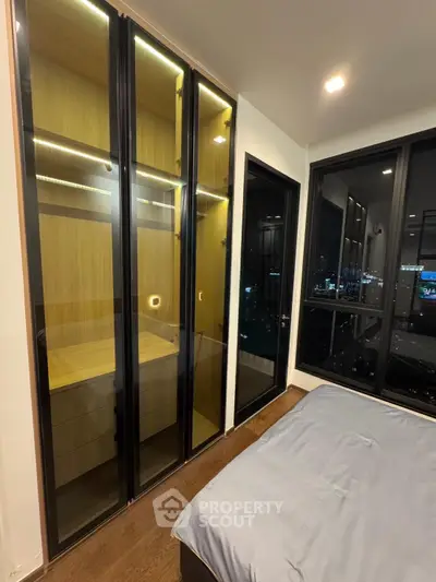 Modern bedroom with city view and sleek glass wardrobe