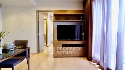 Modern living room with wooden flooring and large TV unit, perfect for cozy family gatherings.
