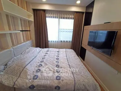 Cozy bedroom with modern decor and wall-mounted TV, perfect for relaxation.