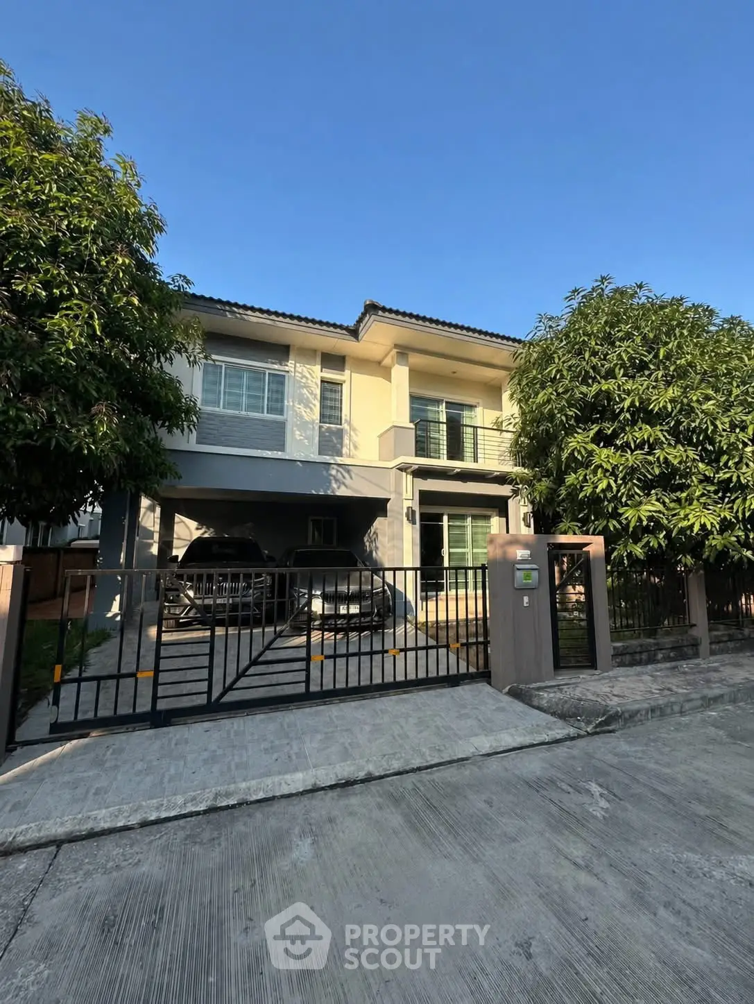 Modern two-story house with spacious driveway and lush greenery, perfect for family living.