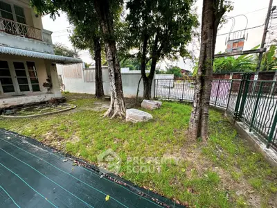 Charming garden space with mature trees in a serene residential area, perfect for outdoor relaxation.