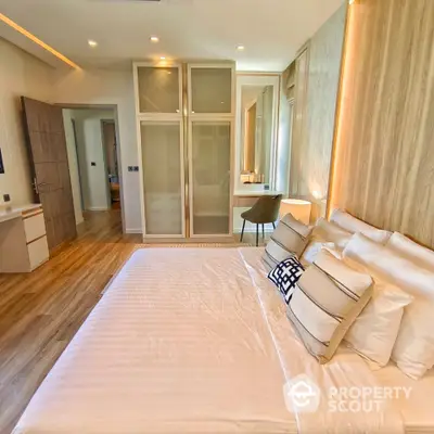 Luxurious bedroom with modern design, featuring a spacious bed and elegant decor.