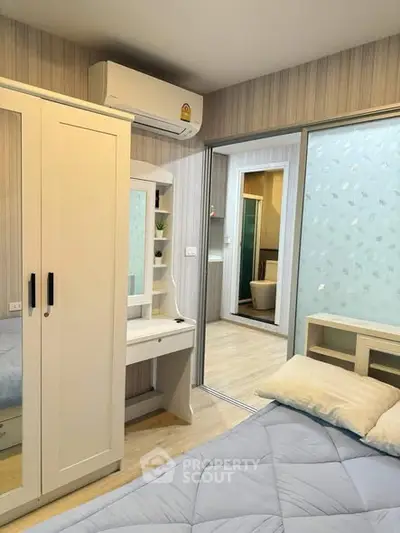 Cozy bedroom with modern decor and ensuite bathroom in stylish apartment.