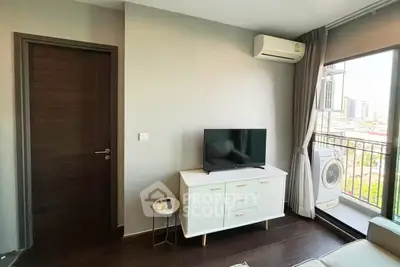 Modern living room with balcony view and washing machine, featuring sleek furniture and air conditioning.