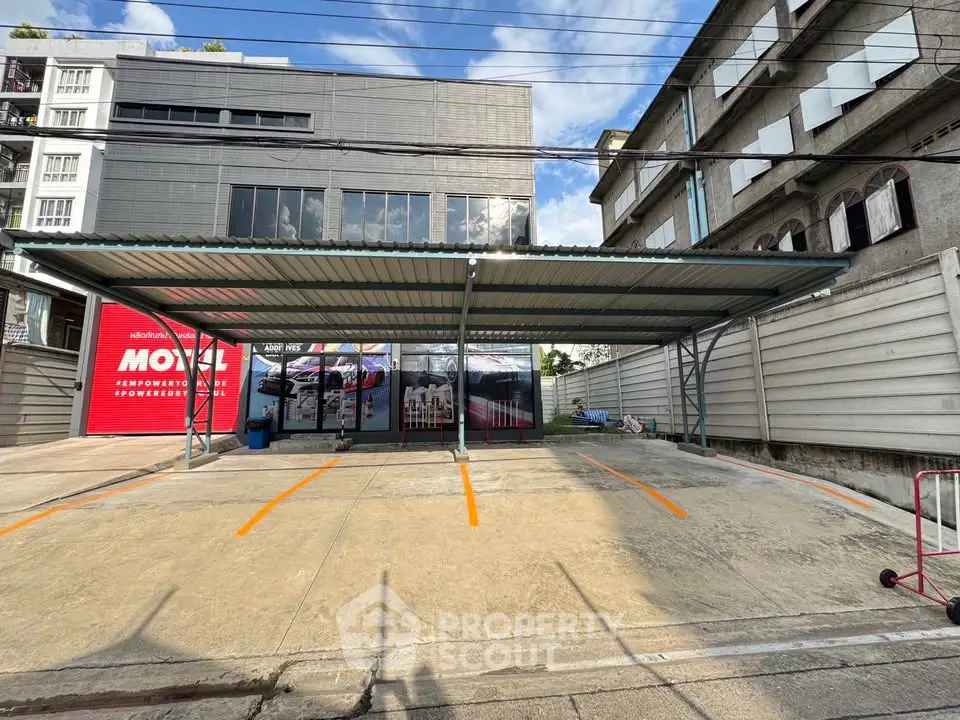 Modern commercial building with spacious parking area and sleek design