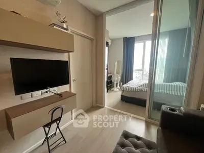 Modern apartment interior with cozy living room and stylish bedroom separated by glass wall.