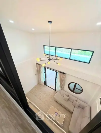 Spacious modern living room with high ceiling and stylish chandelier