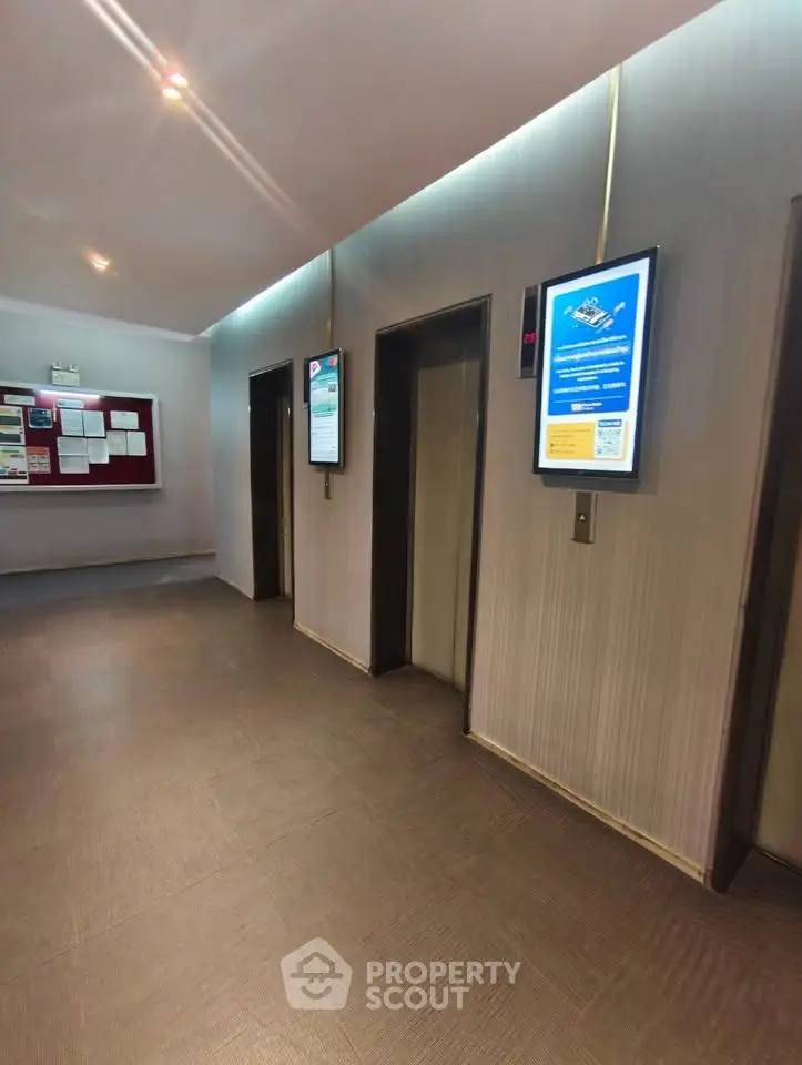 Modern elevator lobby with digital displays and sleek design