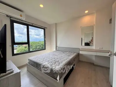 Modern bedroom with large window and scenic view, featuring sleek furniture and ample natural light.