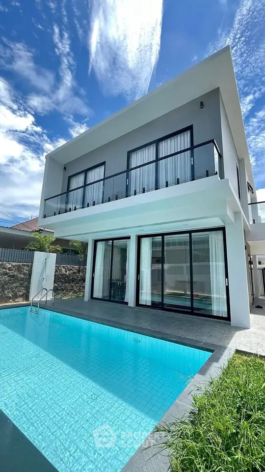 Stunning modern villa with private pool and spacious balcony under a clear blue sky.