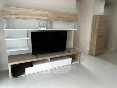Modern living room with sleek wooden TV stand and flat-screen television, perfect for contemporary homes.