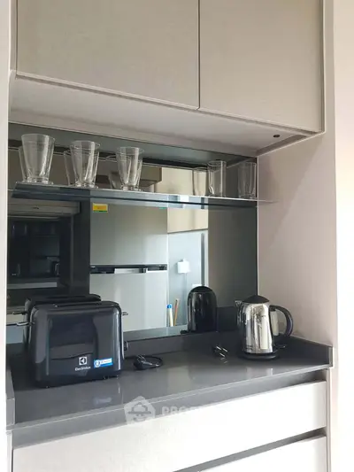 Modern kitchen with sleek appliances and stylish cabinetry, featuring a toaster and electric kettle on the countertop.