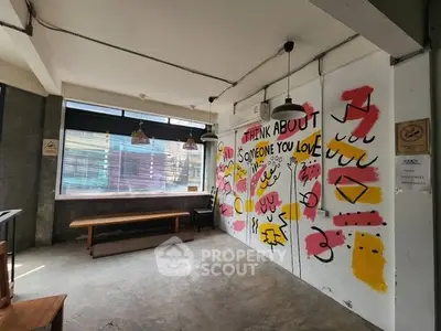 Trendy urban interior with artistic wall mural and industrial design elements.