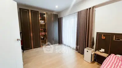 Spacious bedroom with elegant wardrobe and large window for natural light