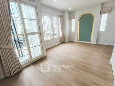 Spacious and bright room with large windows and elegant flooring