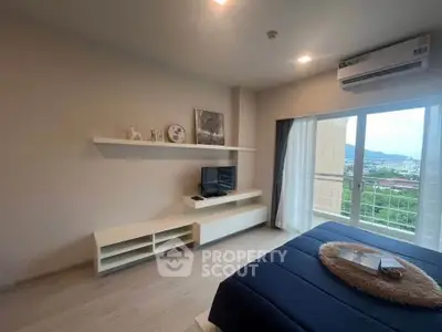 Modern bedroom with balcony and scenic view, featuring sleek furniture and natural light.