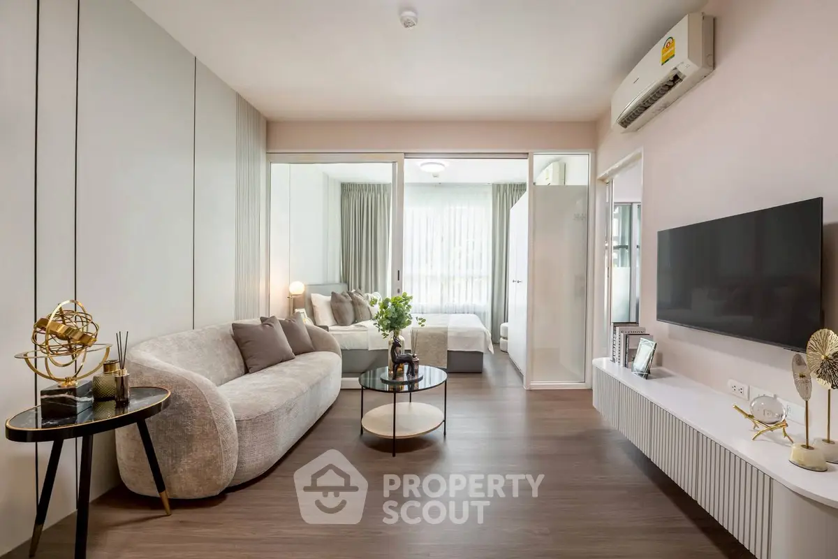 Modern living room with elegant decor and view into cozy bedroom