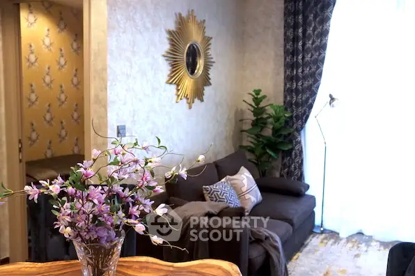 Elegant living room with stylish decor and natural light, featuring a cozy sofa and decorative wall mirror.