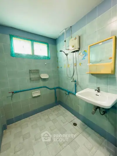 Bright and spacious bathroom with modern fixtures and colorful tiles, perfect for a refreshing start to your day.