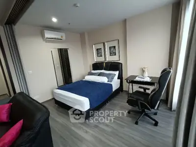 Modern bedroom with stylish decor and workspace in a cozy apartment.