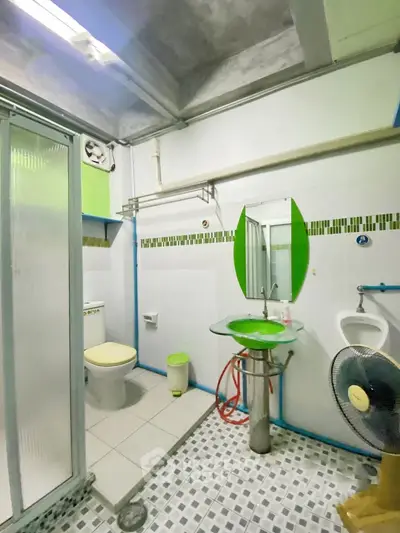Modern bathroom with unique design featuring glass sink and shower enclosure.