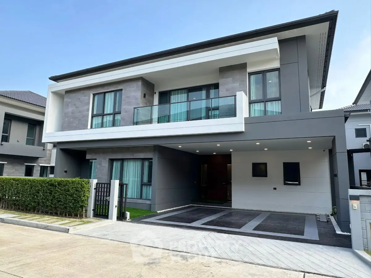 Modern two-story house with sleek design and spacious driveway in a suburban neighborhood.