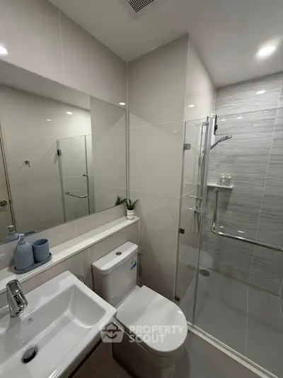 Modern bathroom with glass shower and sleek fixtures in a contemporary home.