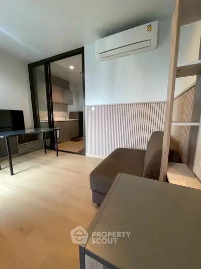 Modern living room with air conditioning and open kitchen layout in stylish apartment.