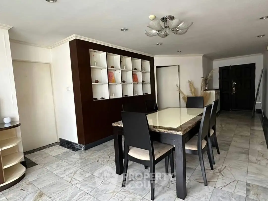 Spacious dining area with elegant marble table and built-in shelving, perfect for modern living.