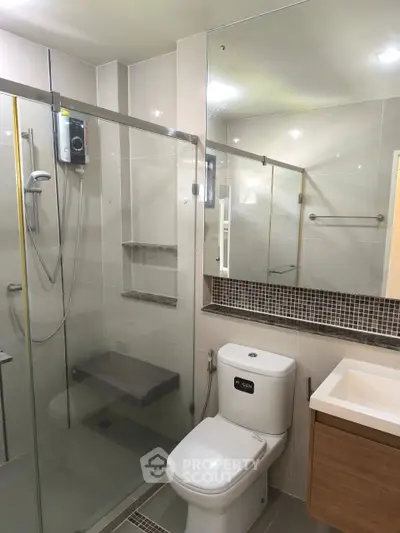 Modern bathroom with glass shower enclosure and sleek fixtures