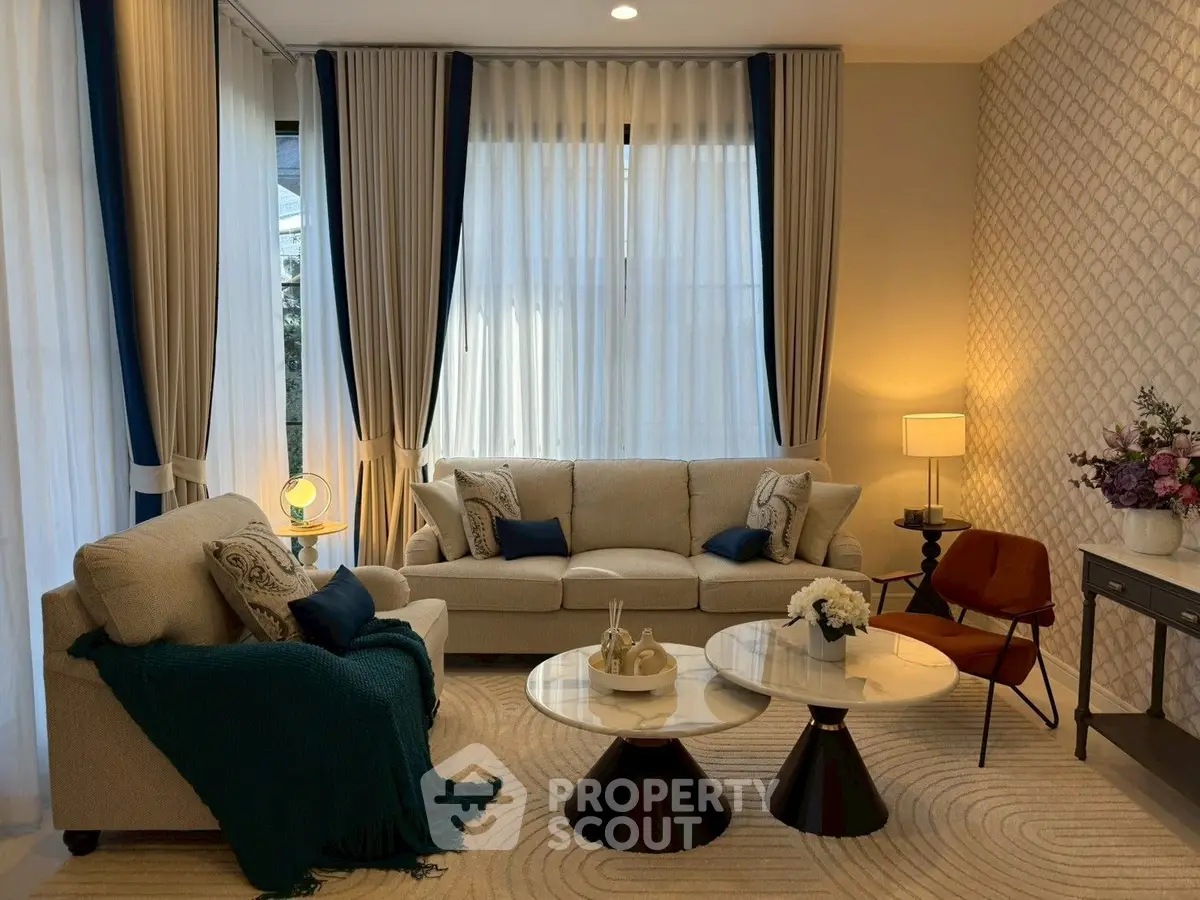 Elegant living room with stylish furniture and modern decor, featuring large windows and cozy seating area.