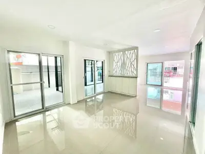 Spacious modern living room with large windows and balcony access