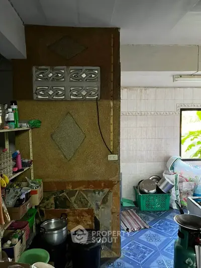 Cozy kitchen with tiled floor and open shelving, featuring a rustic wall design.