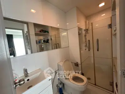 Modern bathroom with glass shower and sleek white fixtures