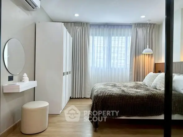 Modern bedroom with cozy decor and natural light, featuring a stylish bed and elegant curtains.