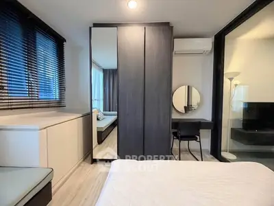 Modern bedroom with sleek design, featuring a large mirror, cozy bed, and stylish decor.