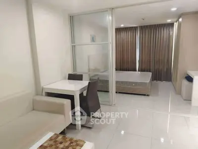 Modern studio apartment with sleek design and open layout, featuring a cozy dining area and spacious bedroom.