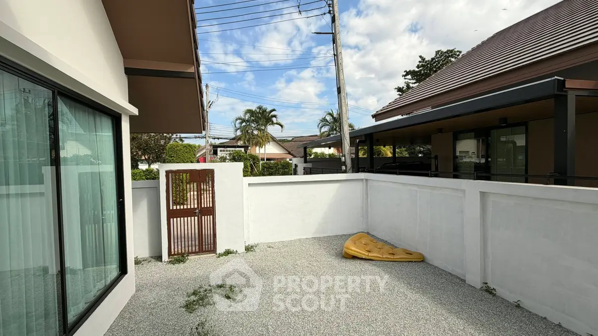 Charming outdoor patio area with privacy wall in a modern residential setting, perfect for relaxation and outdoor activities.